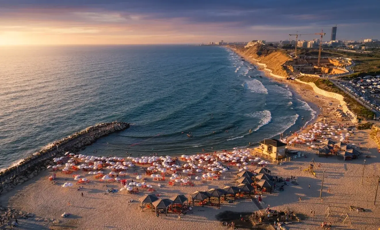 Tel Baruch beach at sunset with Tel Aviv's skyline behind the new district